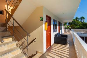 a house with a red door and a black chair at Hotel Boquilla Suites By GEH Suites in Cartagena de Indias