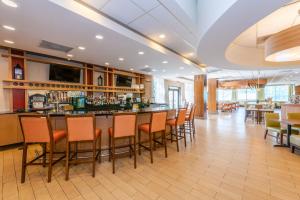 a bar in a restaurant with orange chairs at Doubletree By Hilton Greensboro Airport in Greensboro