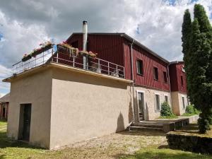 ein rotes Gebäude mit Balkon darüber in der Unterkunft Odzienas Krogusmāja in Odziena