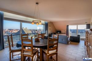 a dining room with a table and chairs with a view at Zandstuyver 0503 in Koksijde