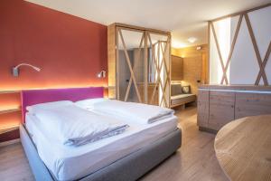a bedroom with a bed with a table and a desk at Veronza Clubresidence in Cavalese +29 photos