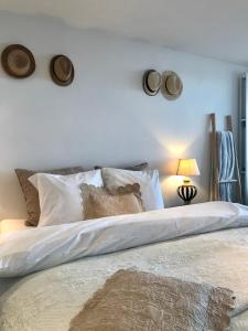 een slaapkamer met een groot bed met witte lakens en kussens bij Sea and Dunes in Knokke-Heist
