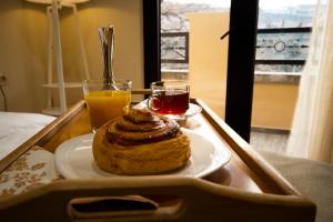 a tray with a pastry and two glasses of orange juice at Hotel Cordata in Tbilisi City