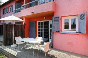 a table and chairs on a deck next to a building at SOWELL RESIDENCES Chênes Verts in Saint-Raphaël