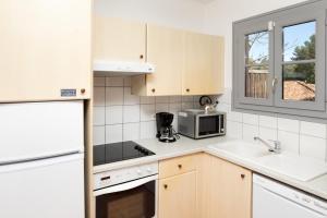 a kitchen with a sink and a microwave at SOWELL RESIDENCES Chênes Verts in Saint-Raphaël