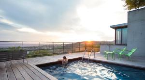 un bambino in una piscina sul ponte di una casa di L'Ermitage Hôtel Cuisine-À-Manger a Saint-Cyr-au-Mont-dʼOr