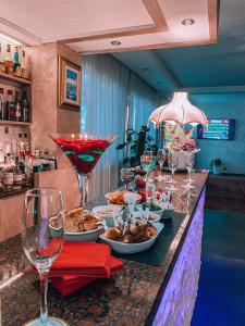 un bar con platos de comida y copas de vino en Hotel Villa, en Bisceglie