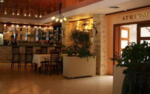 un restaurante con bar, mesas y sillas en Hotel & SPA Odeon, en Boguchwała