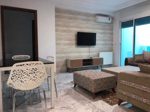 ein Wohnzimmer mit einem Sofa und einem TV in der Unterkunft New Stylish and Spacious Apartment at Berges du Lac 2 Tunis in Tunis