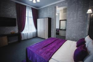 - une chambre avec un lit et une couverture violette dans l'établissement Отель БЕССАРАБИЯ, à Izmaïl