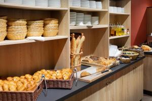 a bakery with lots of bread and baskets on shelves at SOWELL RESIDENCES Chênes Verts in Saint-Raphaël