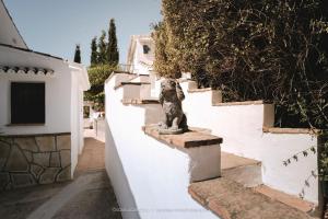 a statue of a dog sitting on the side of a wall at B&B Cortijo Loma León in Cútar