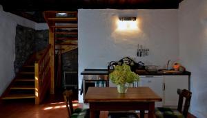 una cocina con mesa y fogones y una escalera en Kapolcs Cottage, en Kapolcs