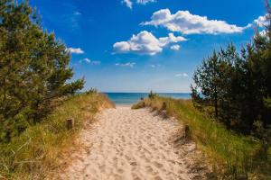 a sandy path leading to the ocean on a beach at Ferienhaus „Sonneninsel“ in Ostseebad Karlshagen