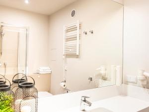 a bathroom with a sink and a mirror at VacationClub - Baltic Park Molo Apartament C304 in Świnoujście