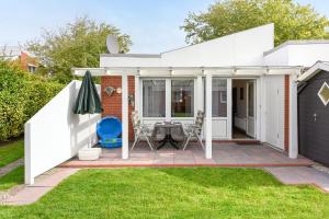 a white house with a patio and grass at Ferienhaus Brigitte in Bensersiel