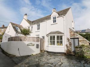 a white house with a fence in front of it at 1 Jubilee Cottage in Tintagel