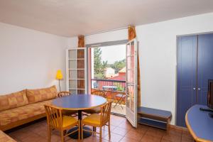 a living room with a couch and a table at SOWELL RESIDENCES Chênes Verts in Saint-Raphaël