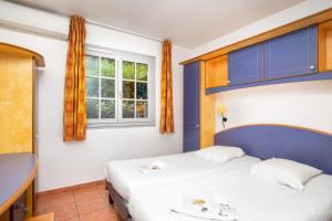 a bedroom with two beds and a window at SOWELL RESIDENCES Chênes Verts in Saint-Raphaël +37 photos