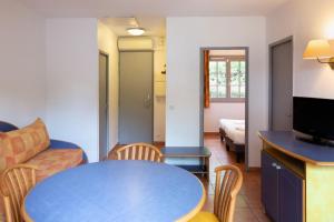 a living room with a blue table and a couch at SOWELL RESIDENCES Chênes Verts in Saint-Raphaël
