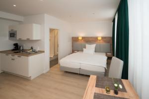 a bedroom with a bed and a table and a kitchen at Haus am Zoo Apartments verschiedene Adressen in Düsseldorf