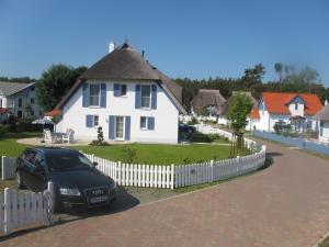 a black car parked in front of a white house at Ferienhaus „Sonneninsel“ in Ostseebad Karlshagen