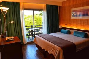 1 dormitorio con 1 cama grande y balcón en Careyes Villa de Mar & Spa en Mar de las Pampas
