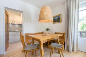 cocina y comedor con mesa de madera y sillas en Ferienwohnungen Alpentraum - Steinböckli, en Oberstdorf