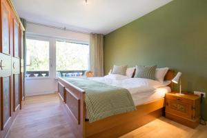 Un dormitorio con una cama grande y una ventana en Ferienwohnungen Alpentraum - Steinböckli, en Oberstdorf