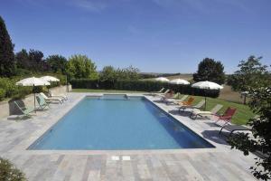 a swimming pool with chairs and umbrellas at Casale il Moro by VacaVilla in Brucciano