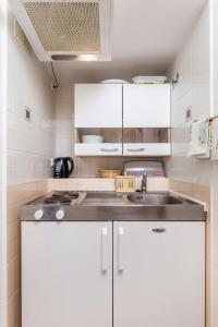 a kitchen with white cabinets and a sink at Apartments Rina in Medveja