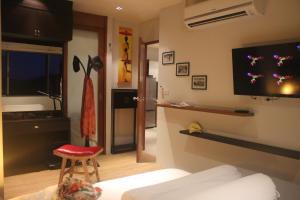 a living room with a bed and a tv on the wall at Top Floor, One-Bedroom Apartment in Phuket