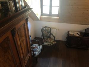 een zolderkamer met een stoel en een raam bij Chata Rovina in Hartmanice