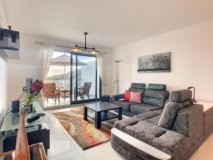 ein Wohnzimmer mit einem Sofa und einem Tisch in der Unterkunft Penthouse Paradisus by LovelyStay in Caniço