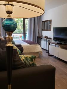 sala de estar con sofá y lámpara en una habitación en URBANA SUITES & STUDIOS 440 en San Carlos de Bariloche