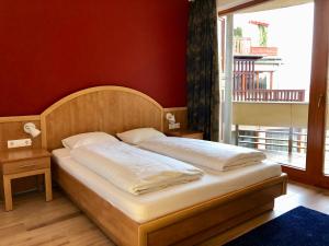 uma cama com uma cabeceira de madeira num quarto em Semiramis Business Hotel em Szolnok