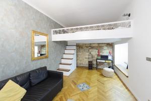 プラハにあるPinkova Apartmentsのリビングルーム(黒いソファ、暖炉付)