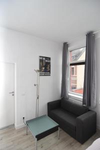 a living room with a black couch and a window at City Apartment Vohwinkel in Gelsenkirchen