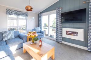 ein Wohnzimmer mit einem Sofa und einem Tisch in der Unterkunft Sea Breeze - Aldeburgh Coastal Cottages in Sizewell