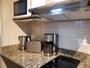 uma cozinha com duas cafeteiras num balcão em URBANA SUITES & STUDIOS 440 em San Carlos de Bariloche