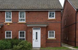 una casa de ladrillo rojo con puerta blanca en 1 Bedroom Apartment Leamington Spa Hosted By Golden Key, en Warwick