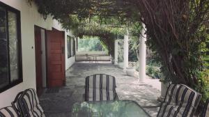 un patio con sillas, una mesa y una puerta en The Riverhouse Guesthouse, en Estcourt