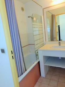 ein Bad mit einem Waschbecken und einer Dusche in der Unterkunft APPARTEMENT 46M², 1 CHAMBRE, PISCINE, TENNIS, PLAGE DIRECT in Sète