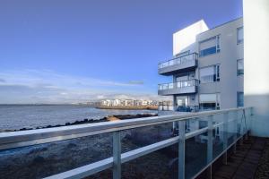 an apartment building with a balcony overlooking the water at Seaside Paradise Apartment in Garðabær