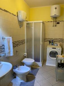 a bathroom with a toilet sink and a washing machine at Guest House Brandino Pani in Tertenìa +18 photos