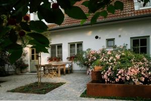 a patio with a table and flowers in front of a house at Auszeit Koppi in Apetlon