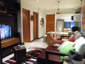 a living room with a couch and a tv at Top Floor, One-Bedroom Apartment in Phuket Town