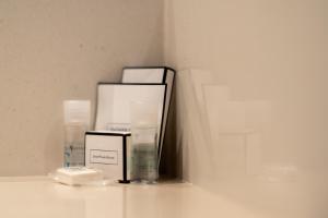 a shelf with three boxes of soap and a glass at Attica 21 Barcelona Mar in Barcelona
