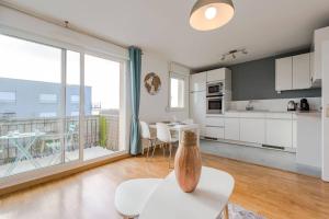 a kitchen with white cabinets and a large window at Crystal apartment Disneyland BMYGUEST in Montévrain