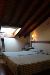 a bedroom with two beds and a skylight at Hostería La Antigua in Potes